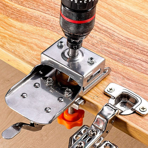 Angled view of metal 35mm hinge boring drill guide with orange knob mounted on wood edge