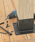Installed Beefy Heavy Duty Metal Post Bracket for Outdoor Use on wooden deck with tools and screws visible