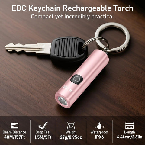 EDC Rechargeable Keychain Flashlight 360 Lumen Mini Pocket Light next to key on wooden surface