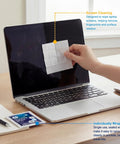 Front view of a laptop screen being cleaned with a premoistened lens cleaning wipe; wipe pack on desk