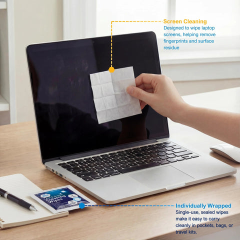 Front view of a laptop screen being cleaned with a premoistened lens cleaning wipe; wipe pack on desk