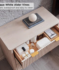 Set Of Two Fluted Nightstands Featuring Three Spacious Drawers And Clean White Alder Finish showing top view with various items and showcasing texture.