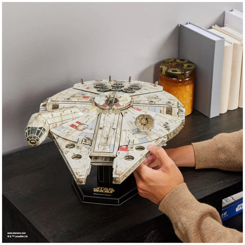 Person assembling Millennium Falcon 3D Model Kit For Star Wars Fans And Collectors, Epic Desk Decor, on bookshelf.