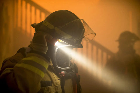Firefighter LED Helmet Light With 180 Degree Articulating Head And Dual Beam Output in smoky environment.