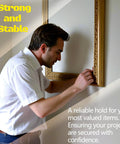 Man securing a frame using All In One Drywall Patch And Anchor Repair Kit With 20 Patches on a wall.