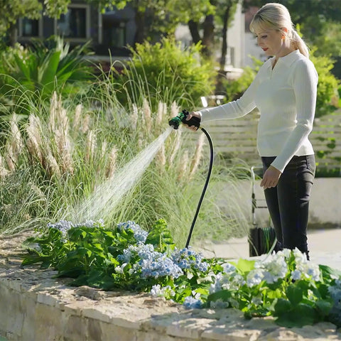 Woman using Foot Pedal Hose Reel Cart With Eighty Two Feet Of One Half Inch Hose, Portable Water Hose Reel On Wheels For Easy Garden Yard And Lawn Cleanup