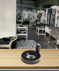 63mm Hand Wheel With Eight Millimeter Bore And Rotating Swivel Handle on workbench in industrial workshop