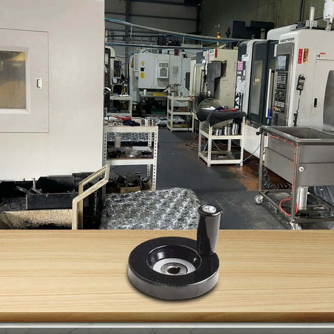 63mm Hand Wheel With Eight Millimeter Bore And Rotating Swivel Handle on workbench in industrial workshop
