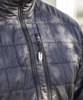 Close-up of ceramic striker fire starter kit zirconia stone hanging from black jacket zipper