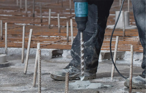 Worker using 1-1/4 Inch By 21 Inch SDS-Max Speed-X Rotary Hammer Bit For Concrete Drilling With Inclined Side Cutters on construction site