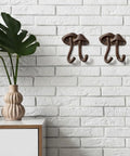 Straight Up Legit Mushroom Wall Hooks Set Of Two Heavy Duty Cast Iron Coat Hangers With Antique Black Finish mounted on white brick wall.
