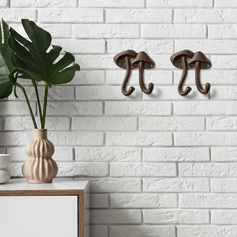 Straight Up Legit Mushroom Wall Hooks Set Of Two Heavy Duty Cast Iron Coat Hangers With Antique Black Finish mounted on white brick wall.