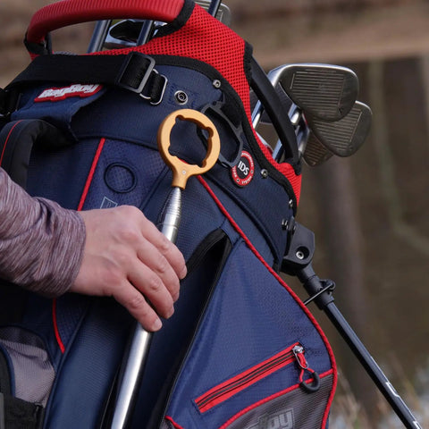 Hide Away Golf Ball Retriever with 18 Foot Reach in Bright Orange attached to golf bag, highlighting magnetic gripper head.