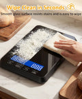 High Precision 33 Lb Digital Kitchen Scale With 0.1 Oz Accuracy being wiped clean, showing clear glass surface with backlit display