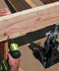 Powerbuilt 3-Ton all-in-one hydraulic bottle jack and jackstand unit; compact with a wide base under a wooden beam.