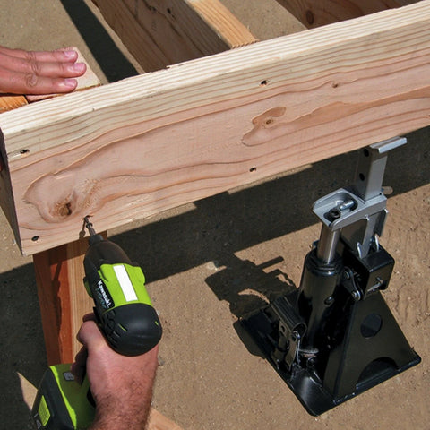 Powerbuilt 3-Ton all-in-one hydraulic bottle jack and jackstand unit; compact with a wide base under a wooden beam.