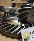 Close-up of Bevel Gear Set 12 By 32 For Tractors Fits 5045E Through 5725 Series Heavy Duty Replacement Gear on cardboard surface.