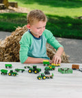 Child playing with John Deere Farm Toy Set 1 64 Scale Tractors And Trucks Playset With Fencing And Horse Figure 26 Piece Collection