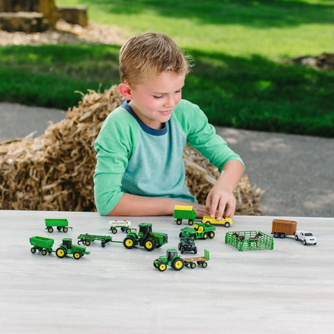 Child playing with John Deere Farm Toy Set 1 64 Scale Tractors And Trucks Playset With Fencing And Horse Figure 26 Piece Collection