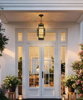 Built Like A Tank Modern Pendant Ceiling Light For Indoors Or Outdoors, Totally Waterproof Black Aluminum Porch Lantern Featuring Textured Water Ripple Glass, Includes Matching Bulb, hung over a white entry door.