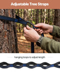 Person setting up ultralight camping hammock for hiking and travel with adjustable tree straps wrapped around a pine tree.