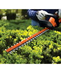 20V Max Cordless Hedge Trimmer With 22 Inch Dual-Action Steel Blade used on bushes in a garden