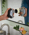 Person using Versa Power Scrubber Grout Brush And Shower Cleaning Tool For Tile Grout Sinks Stovetops Tubs Pans And Grills Grime Busting Compact Ergonomic Kitchen And Bath Cleaner For Auto Surfaces on bathroom mirror