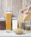 Airtight Food Storage Containers With Lids 7 Piece BPA Free Kitchen Canisters for Spaghetti Pasta Flour Sugar and Dry Goods filled with oats on a kitchen counter.