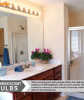 Bathroom vanity mirror with incandescent bulbs providing warm light, clear view of countertop items, towel, and a shower area.