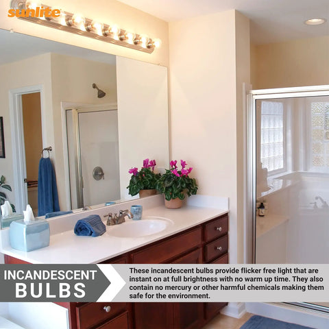 Bathroom vanity mirror with incandescent bulbs providing warm light, clear view of countertop items, towel, and a shower area.
