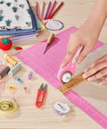 Person using 45mm Rotary Cutter With Five Extra SKS7 Stainless Steel Blades, Ergonomic Pink Handle, Safety Lock on fabric