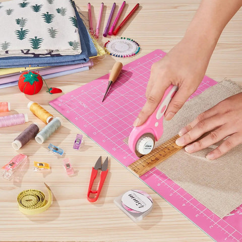 Person using 45mm Rotary Cutter With Five Extra SKS7 Stainless Steel Blades, Ergonomic Pink Handle, Safety Lock on fabric