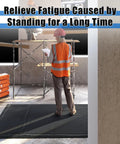 Worker standing on 3 By 7 Foot Anti Fatigue Floor Mat Extra Thick One Inch For Machinist Shop Garage Standing Pad With Anti Static Rubber Top EPDM Foam Core And Conductive Bottom To Reduce Foot And Leg Fatigue Black in construction area.