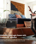 Musician playing guitar with Katana 50 Gen 3 50-Watt 1x12 Guitar Combo Amp Bundle placed on stage near plant and seating area.