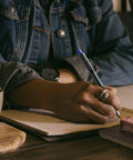 Person writing with Kuru Toga Mechanical Pencil Starter Kit 0.7mm HB2 Lead With Rotating Tip Mechanism in a notebook
