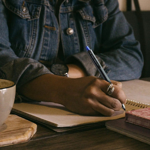 Person writing with Kuru Toga Mechanical Pencil Starter Kit 0.7mm HB2 Lead With Rotating Tip Mechanism in a notebook