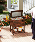 54-Quart Rolling Cooler Cart With Two Drop Leaf Tables Built In Bottle Opener Pine Wood Outdoor Beverage Cooler On Wheels Party Ready For Backyard Parties Yard Pool Deck Patio pictured on a patio with beverages and a person nearby