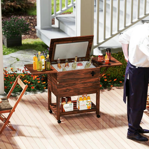 54-Quart Rolling Cooler Cart With Two Drop Leaf Tables Built In Bottle Opener Pine Wood Outdoor Beverage Cooler On Wheels Party Ready For Backyard Parties Yard Pool Deck Patio pictured on a patio with beverages and a person nearby