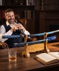Beast Mode Spring Steel Katana Hand Forged Plum Blossom Samurai Sword displayed on wooden stand in luxurious study setting.