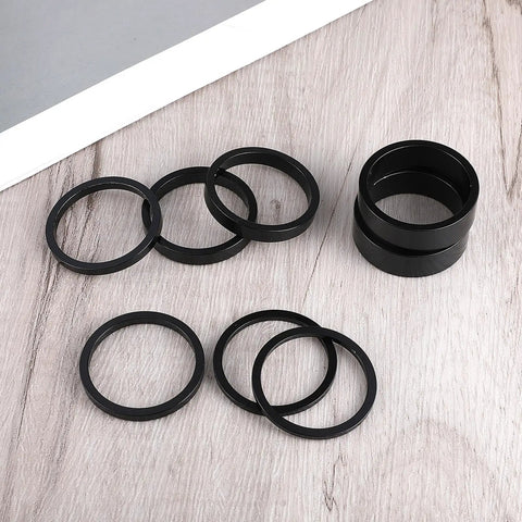Eight Piece Aluminum Bike Headset Spacers Set For One And One Eighth Inch Stems With 2mm 3mm 5mm And 10mm Spacers on wood surface
