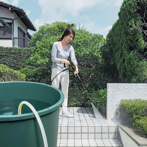 Person using Water Suction Hose With Filter For Electric Pressure Washers, Easy Fit Debris Filtering in garden.