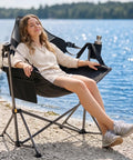 Woman relaxing by lake in Heavy Duty Folding Hammock Chair With Adjustable Backrest For Camping, Travel, And Patio
