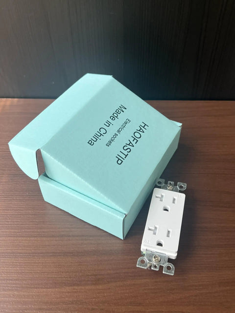 Top Shelf Modern Wall Socket With Two Openings Heavy Duty Electrical Receptacle Plug rated for twenty amps next to packaging on wood surface.