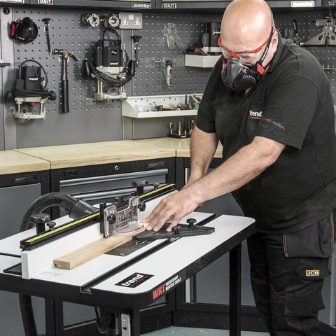 Woodworker using Rock Solid Free Standing Router Table With Heavy Duty Steel Base And Spacious 24 By 16 Inch Laminated Top.