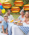 Adults and child at picnic with 7 Pack 28 Inch Hot Dog Balloons Foil Mylar Helium Balloons For BBQ Picnic Birthday Carnival Cookout Party
