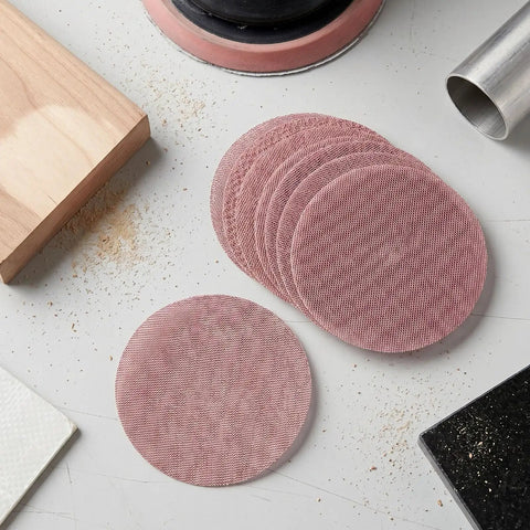 Super Cool 5 inch Mesh Sanding Discs With Hook And Loop Backing, 240 Grit Fine Aluminum Oxide For Wood and Metal Project Dust Free Set of 50 stacked on a work surface.