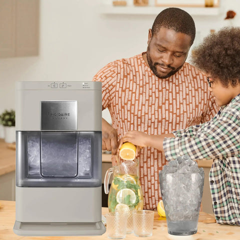 Cream Countertop Nugget Ice Maker With Visible Window And Sleek Touchscreen that cranks out ice, with family preparing drinks.