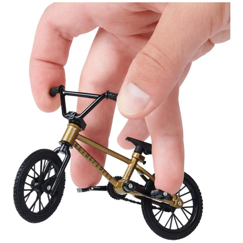 Close-up of hand holding BMX Finger Bike 3-Pack Officially Licensed Totally Customizable Collectible Mini Replica Toys with metal frame.
