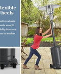 Woman moving Outdoor Patio Heater With 50,000 BTU Propane Heater, Stainless Steel Burner, Wheels, And Triple Protection on patio