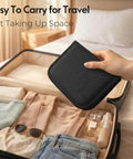Hand placing Travel Friendly Portable Sewing Kit With All The Essentials Thread Needles Scissors And Basic Tools in a suitcase